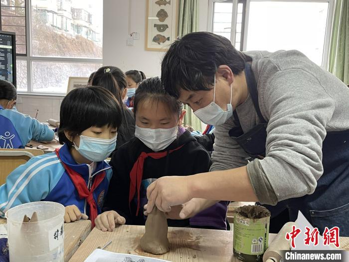 圖為西寧市勞動路小學教師賈煜與學生一起制作陶藝。　周瑞辰子 攝