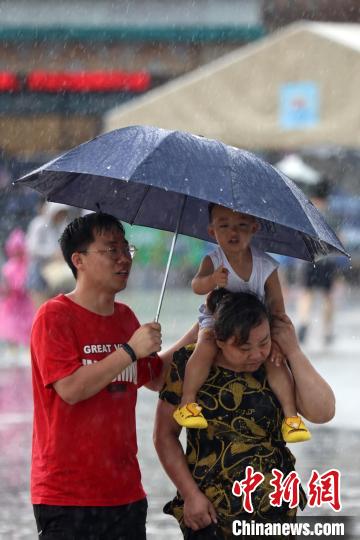 市民冒雨前行。　泱波 攝