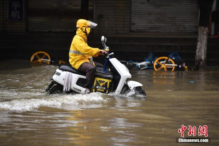 資料圖：外賣小哥通過(guò)積水路段。<a target='_blank' href='http://www.chinanews.com/'>中新社</a>記者 劉冉陽(yáng) 攝