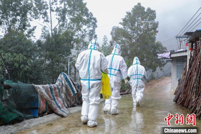 圖為在德?？h隆桑鎮(zhèn)果甫村，身著厚重防護(hù)服的歐秋潔和同伴步履蹣跚地行走。