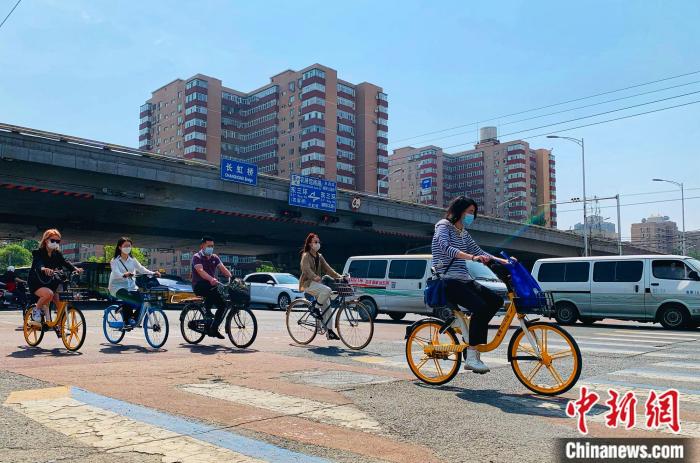 5日，北京東三環(huán)附近正騎單車出行的市民。