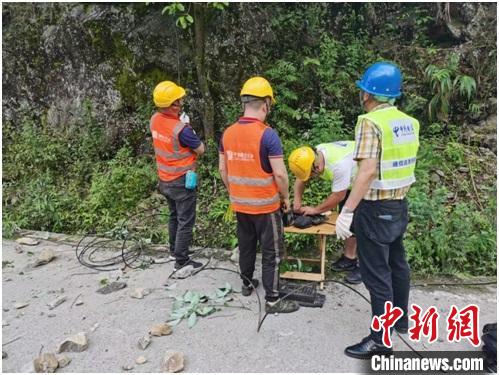 中國電信搶險人員在寶興和蘆山之間小漁溪進行光纜搶修?！≈袊娦潘拇ü竟﹫D