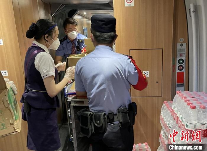 乘警與列車工作人員一起運(yùn)送礦泉水?！⌒熘蓁F路公安處供圖