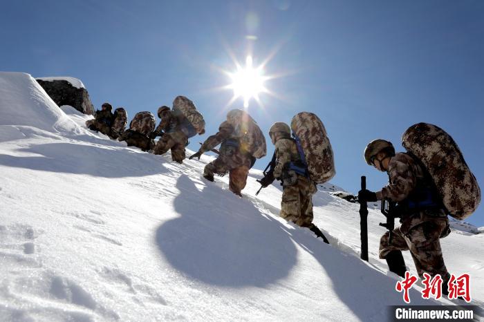 圖為巡邏官兵翻越雪山?！●R軍 攝