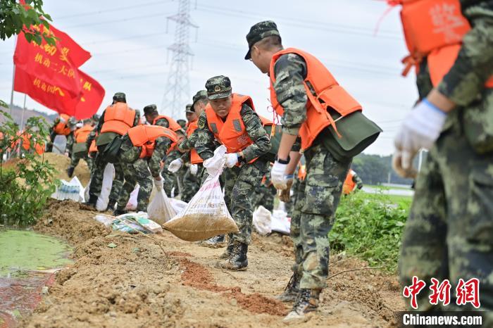 武警江西總隊(duì)機(jī)動(dòng)支隊(duì)官兵奔赴江西景德鎮(zhèn)市樂(lè)平市開(kāi)展搶險(xiǎn)救援，傳遞沙袋。　彭丁 攝