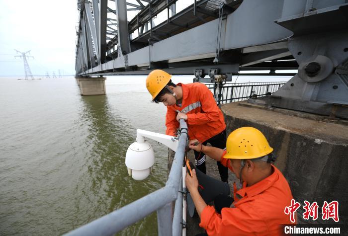 6月24日，南鐵九江橋工段的橋梁工正在九景衢鐵路鄱陽湖大橋上對監(jiān)控攝像頭進行檢修?！『鷩?攝