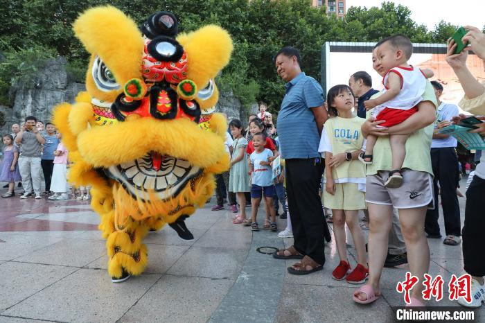 賴翊凡(獅頭)與李洪江配合在縣城詩(shī)鄉(xiāng)廣場(chǎng)練習(xí)舞獅吸引市民觀看?！■暮陚?攝