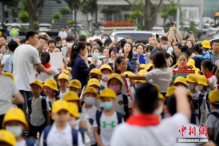 資料圖：新生家長們目送學(xué)生進(jìn)入校園。 <a target='_blank' href='/'>中新社</a>記者 張瑤 攝