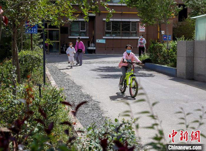 烏魯木齊市水磨溝區(qū)七道灣東街南社區(qū)，居民下樓在小區(qū)內(nèi)活動(dòng)?！＄娦?攝