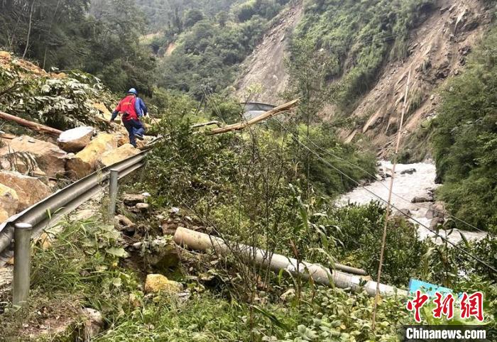 電力搶險人員快速通過危險路段，旁邊是受損的電力線路 四川電力供圖