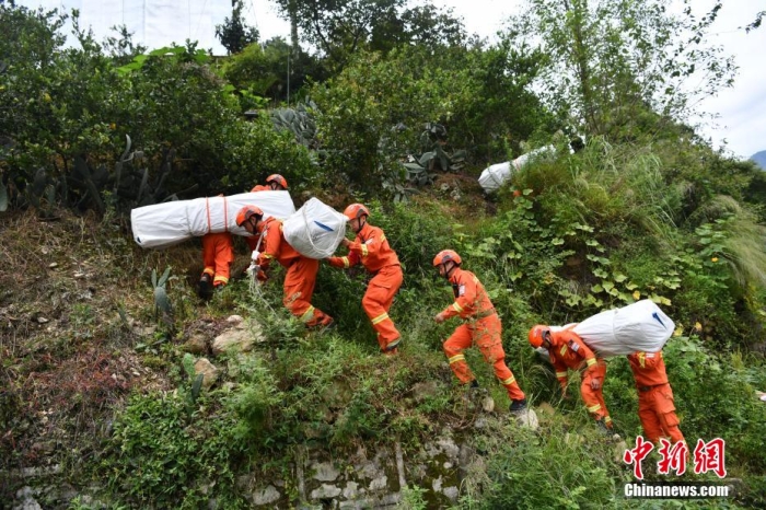 資料圖：消防員徒步運送帳篷物資。 張浪 攝