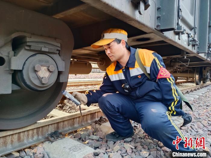 圖為張建亮在檢查車輛軸承溫度?！≈炜△?攝