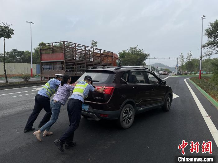 佛山高明公安警輔人員協(xié)助司機(jī)將故障車輛推至安全區(qū)域?！∥轲┤?攝