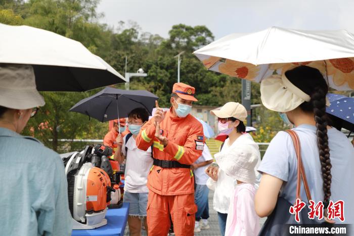 森林消防員正在為游客進行滅火裝備展示講解及森林防火常識科普?！↑S山鴻 　攝