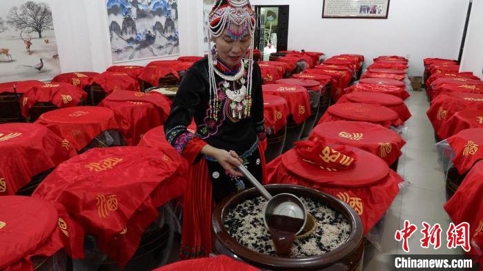 圖為藍(lán)春花在酒廠查看最新釀造的米酒。　記者華山 攝