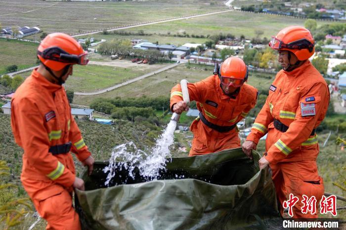 技能大練兵過程中，消防員在陡坡上向蓄水池注水?！±顕?guó)燾 攝