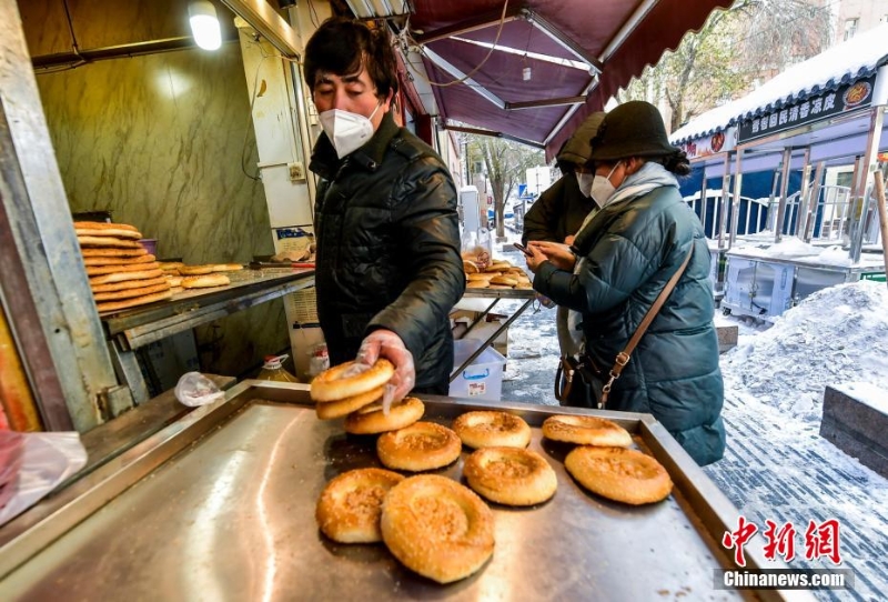 烏魯木齊市文化路，已開門營業(yè)的馕店吸引過往市民前來購買。 劉新 攝