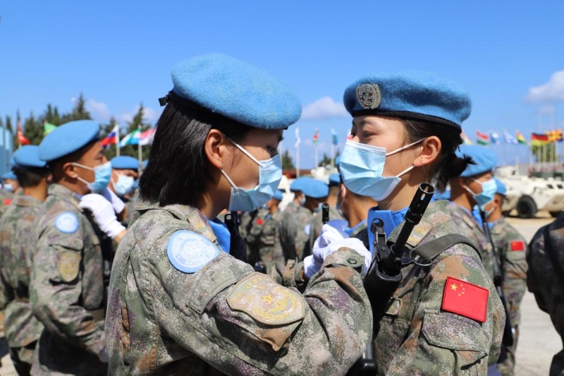 圖為2021年6月16日，在黎巴嫩南部辛尼亞村中國(guó)維和營(yíng)舉行的授勛儀式上，接受檢閱的維和女兵進(jìn)場(chǎng)前互相整理著裝。（新華社發(fā)）