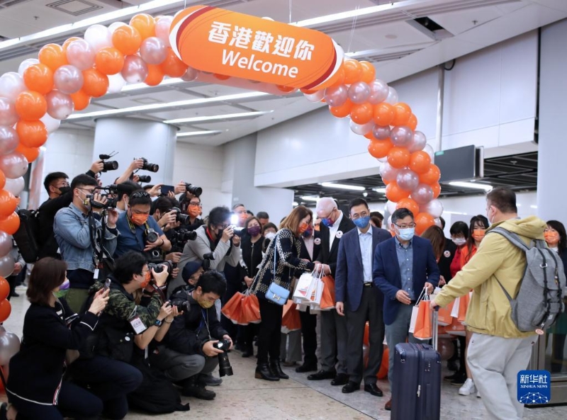 1月15日，在香港的西九龍站，工作人員迎接恢復通車后內地駛往香港首趟列車的旅客并贈送小禮物。新華社記者 李鋼 攝