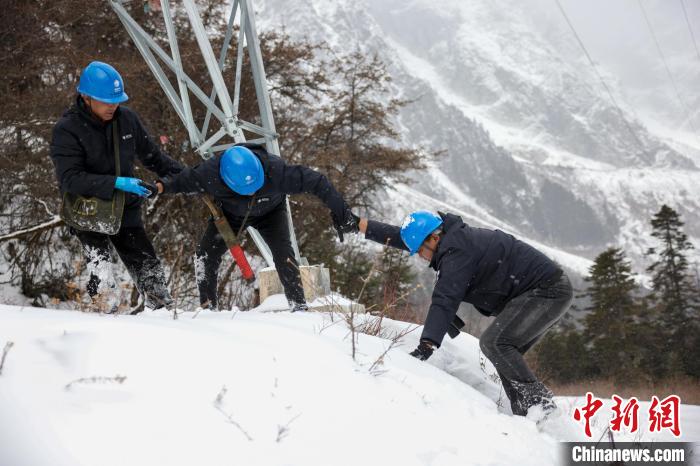 西藏波密縣電力巡護人員相互幫助，趟雪踏冰。　李東淮 攝