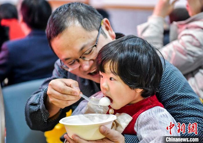 市民和孩子一起品嘗湯圓。　劉新 攝