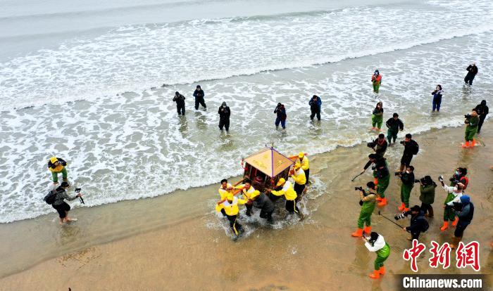 信眾抬著神轎沖海祈福。　陳斌 攝