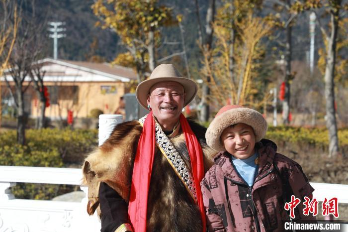 圖為林芝市巴宜區(qū)布久鄉(xiāng)仲果村村民桑杰與孫子一起參加藏歷新年活動?！埩?攝