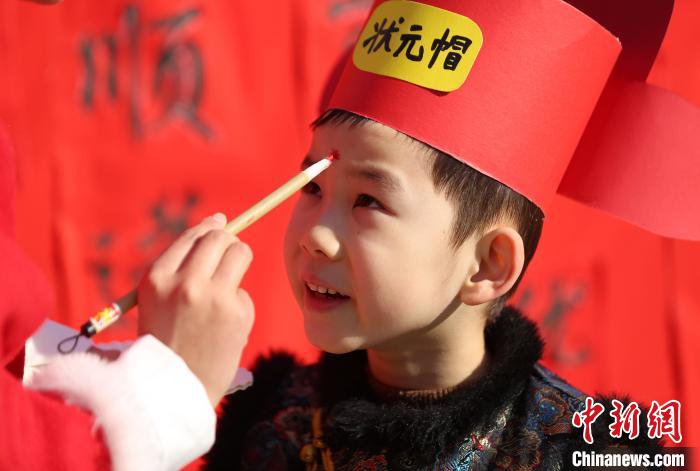 臨沂市沂南縣第二實驗幼兒園的老師在學(xué)生額頭點朱砂“開蒙”，寓意孩童從此打開“天眼”，眼明心明?！⊥鯊┍?　攝