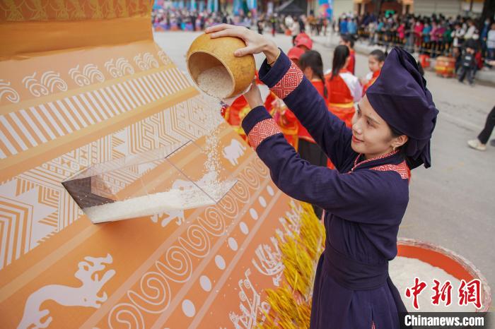 圖為民眾將稻米倒入谷倉(cāng)，寓意五谷豐登、糧倉(cāng)滿滿?！￡惞谘?攝