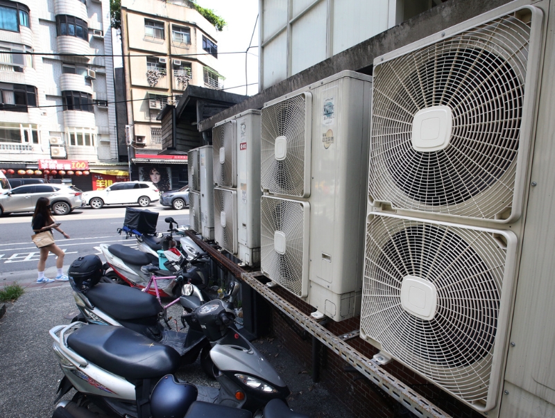 臺灣第二核能發(fā)電廠2號機14日期滿除役，外界擔心影響供電。圖為一位民眾走過成排的冷氣室外機。（圖源：臺灣“中時新聞網(wǎng)”）