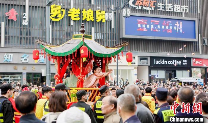 蠶花姑娘將寓意祝福的蠶花、糖果拋向民眾 新市鎮(zhèn)供圖