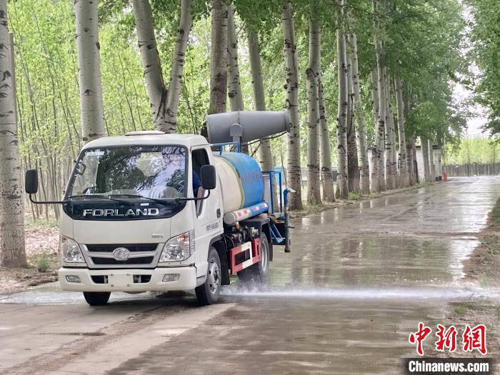 圖為灑水車在對地面進行濕化，降低飄絮強度?！⌒戽?攝