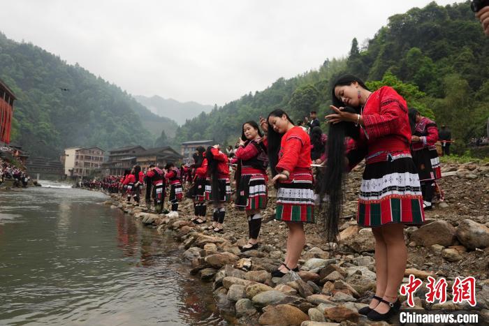 4月22日，在廣西龍勝各族自治縣龍脊鎮(zhèn)黃洛瑤寨，當(dāng)?shù)噩幾迕癖娫诤舆呴_(kāi)展長(zhǎng)發(fā)梳妝表演?！№f吉陽(yáng) 攝