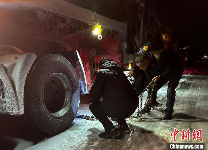 圖為民警幫助受困車輛安裝防滑鏈?！」逯菸麄鞑抗﹫D