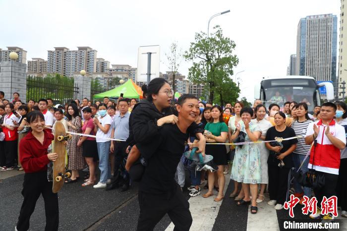 圖為蔣張子怡的父親背著她往外走，母親拿著女兒的滑板跟在后面?！⒄祭?攝