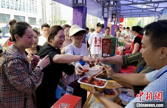 圖為江西南昌英雄城啤酒龍蝦燒烤節(jié)上，游客爭相品嘗鐵河小龍蝦預制菜?！⌒陆▍^(qū)融媒體中心供圖