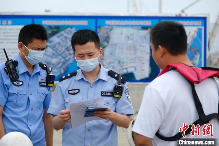 平潭邊檢站移民管理警察對(duì)船員證件進(jìn)行查驗(yàn)?！±钭谒?攝