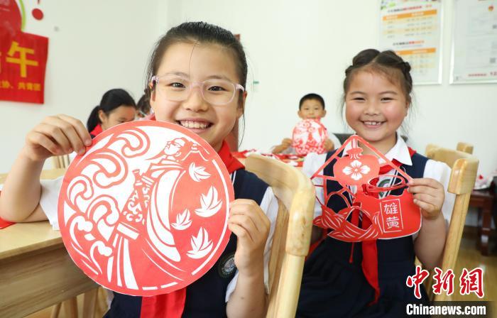 安徽省肥西縣上派鎮(zhèn)四十埠社區(qū)服務中心里，小學生們展示自己的剪紙作品?！￡惣覙?攝