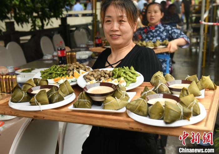 圖為服務(wù)員正在將粽子送上餐桌。　周毅 攝