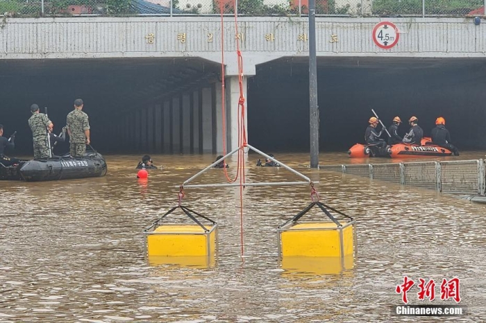 韓國救援人員沿著一條被洪水淹沒的道路搜尋失蹤人員，這條道路通往被洪水淹沒的地下隧道。視覺中國