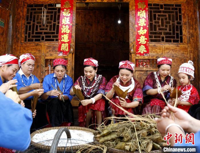 施秉縣楊柳塘鎮(zhèn)板屯村陸地坪苗寨苗族女同胞們圍坐一起包粽粑，共慶“六月六”粽粑節(jié)。　奉力 攝