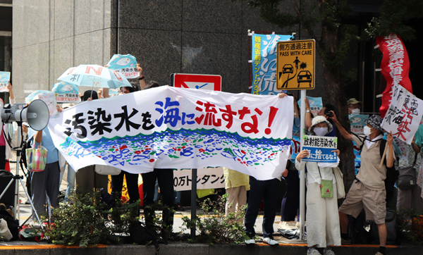 8月24日，日本民眾手持“不許將污染水排入大?！钡葮苏Z在東京電力公司總部前集會，抗議日本政府和東電公司無視民意啟動核污染水排海。（圖源：新華網(wǎng)）